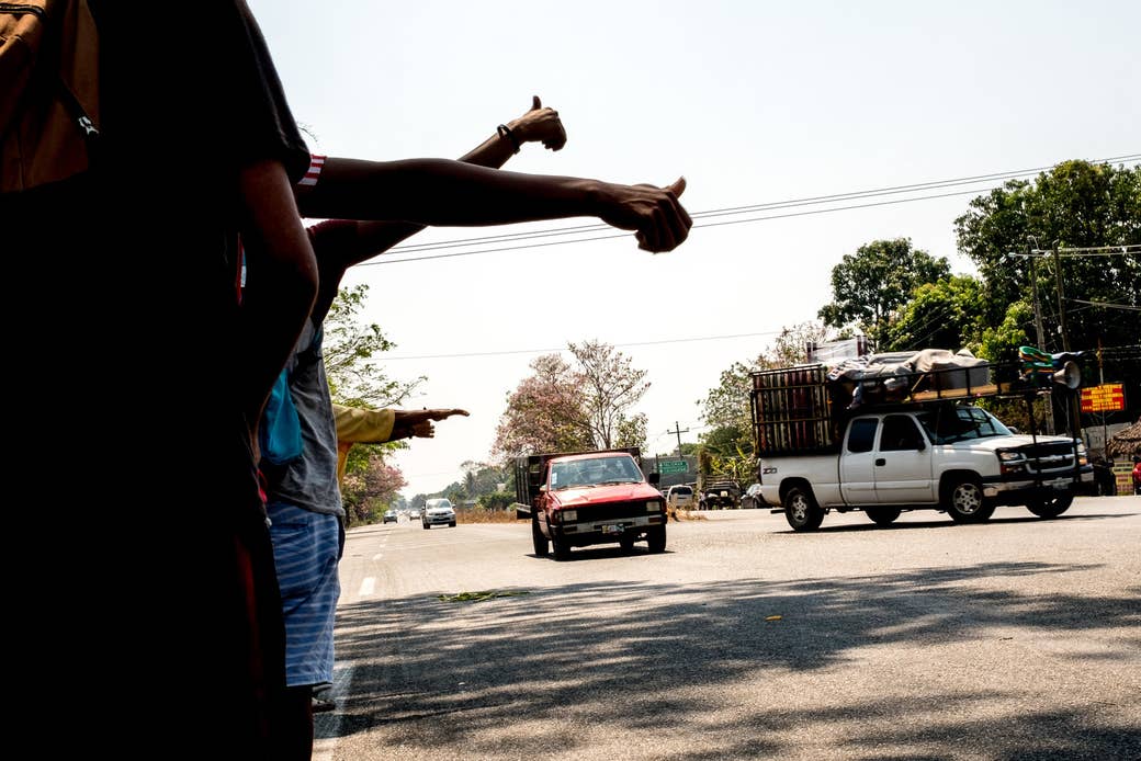 Migrants hitchhike along the side of the highway as they move toward the city of Mapastepec, Chiapas.