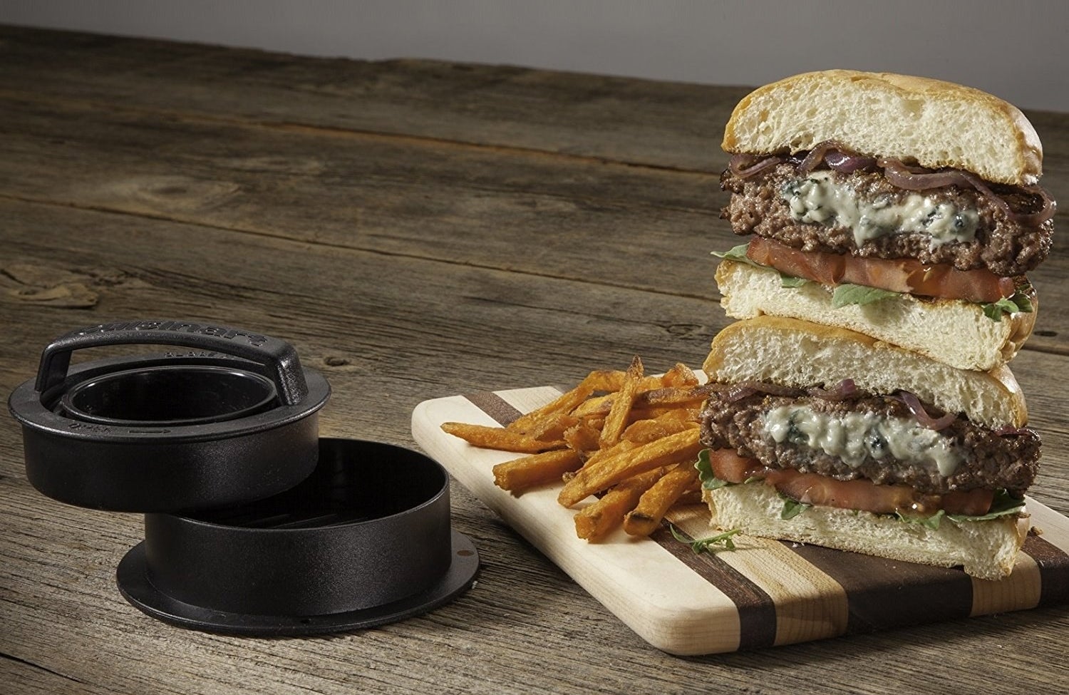 A burger cut in half so the stuffed middle of the patty is visible next to the stuffed patty mold