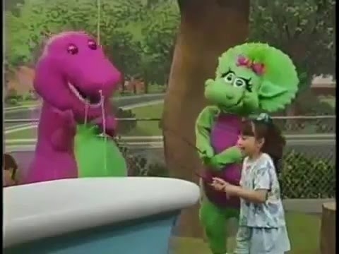 A screenshot of Barney and Baby Bop playing fishing with a little girl.