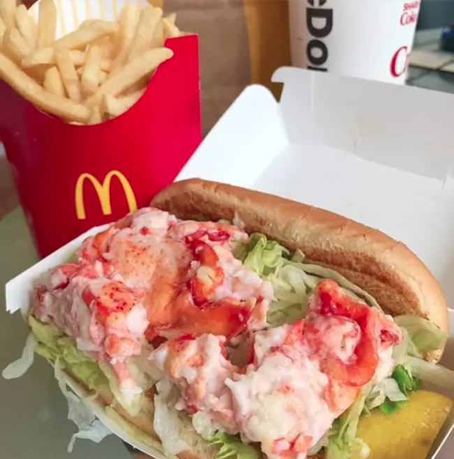 Close-up of a lobster roll with a side of fries