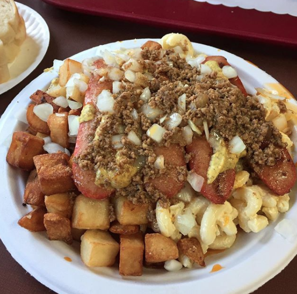 Close-up of home fries, macaroni salad, onion, and ground meat on a plate