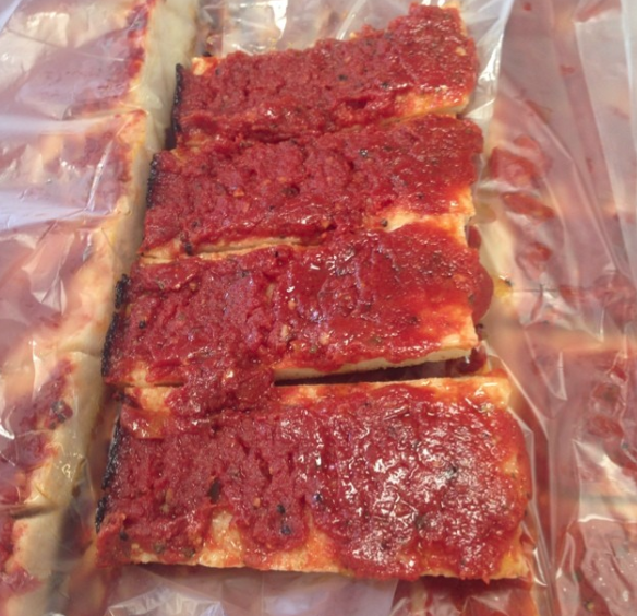 Close-up of crust slices covered in tomato sauce
