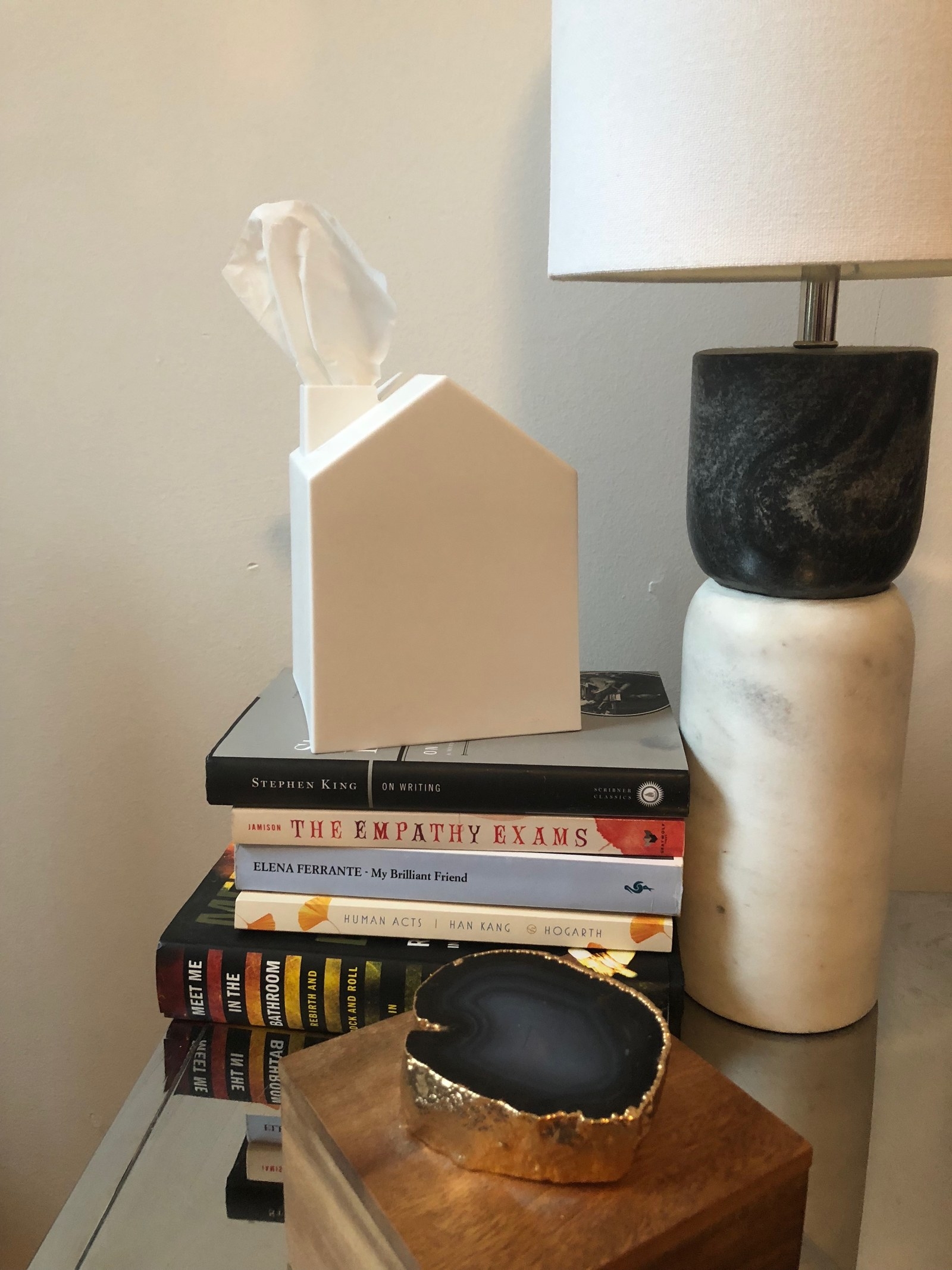 The white tissue box covers sitting on a stack of books