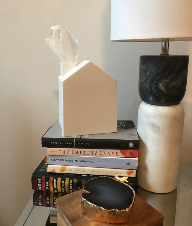 The tissue box covers sitting on a stack of books
