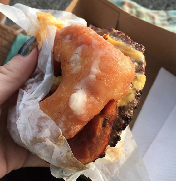 Close-up of a cheeseburger and a donut
