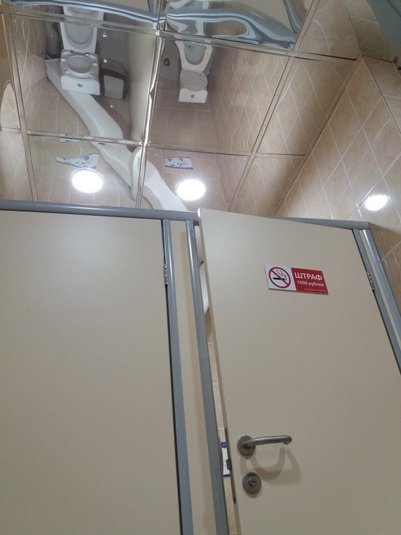 This very public bathroom with a mirrored ceiling.