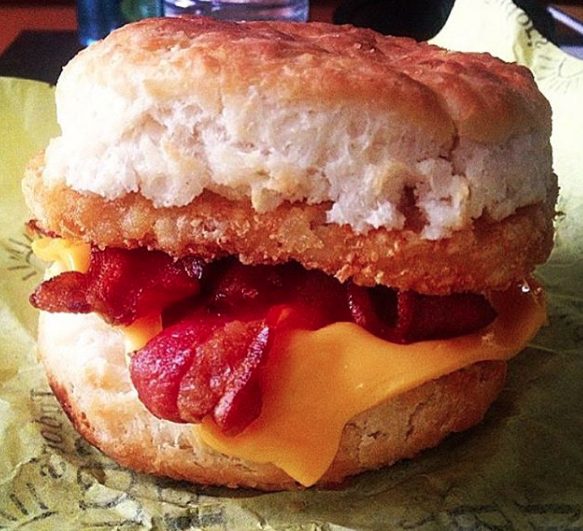 Close-up of a cheeseburger with bacon and a biscuit bun