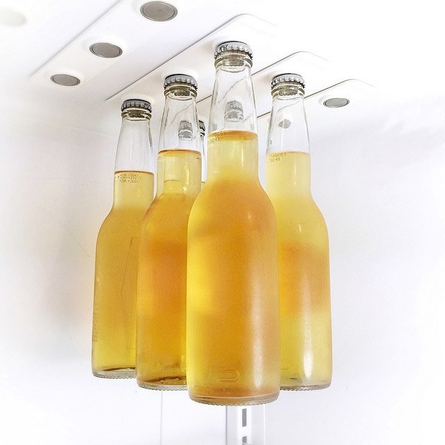 view of inside roof of the fridge with magnetic strips that are strong enough for beer bottles to stick to them, leaving lots of storage room below the bottles