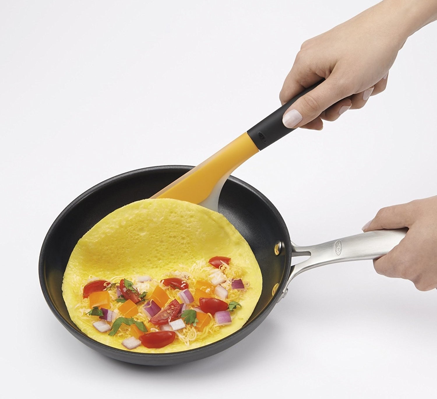 The spatula folding an omelet in half