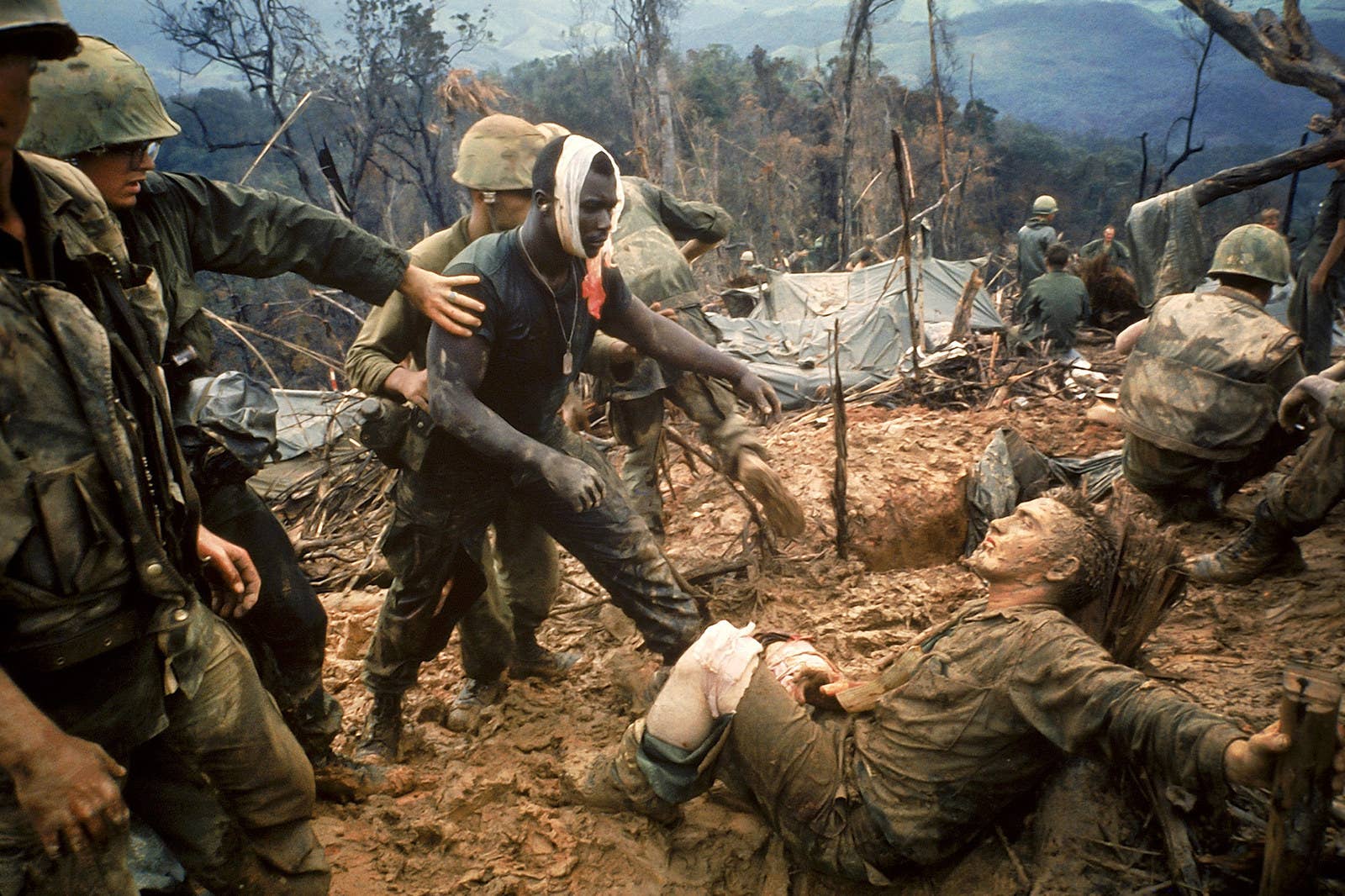 Ferido, o sargento Jeremiah Purdie (centro) passa por outro combatente ferido após uma intensa troca de tiros pelo controle de um território.