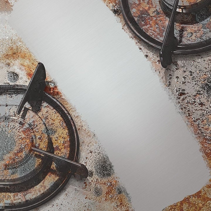 A stove coated in grease with a clean white line  scrubbed through it