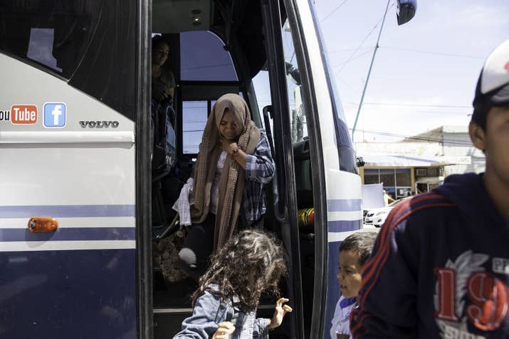 Women and children from the migrant caravan exit a bus in Mexicali, where they were given food, rest and medical attention, if they needed it.