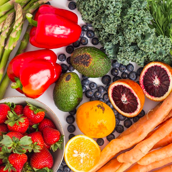 assorted produce, including strawberries, lemons, avocados, peppers, carrots, asparagus, blueberries, kale, and blood oranges