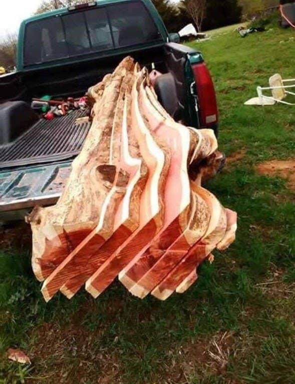 Large blocks of a tree bark in the back of a truck that look like bacon slices