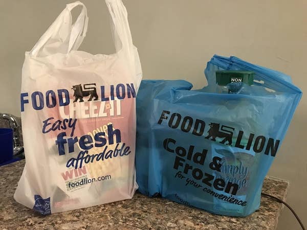 Two grocery bags, one white and one blue. The blue one says &quot;cold and frozen.&quot;