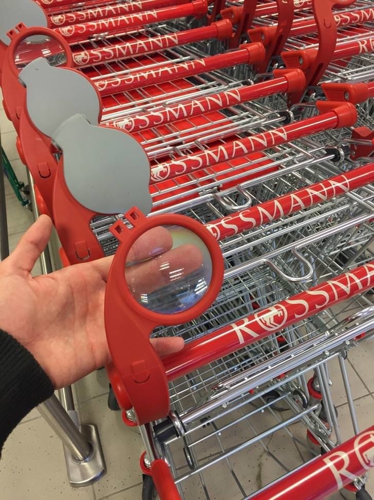 A magnifying glass affixed to a grocery cart handle