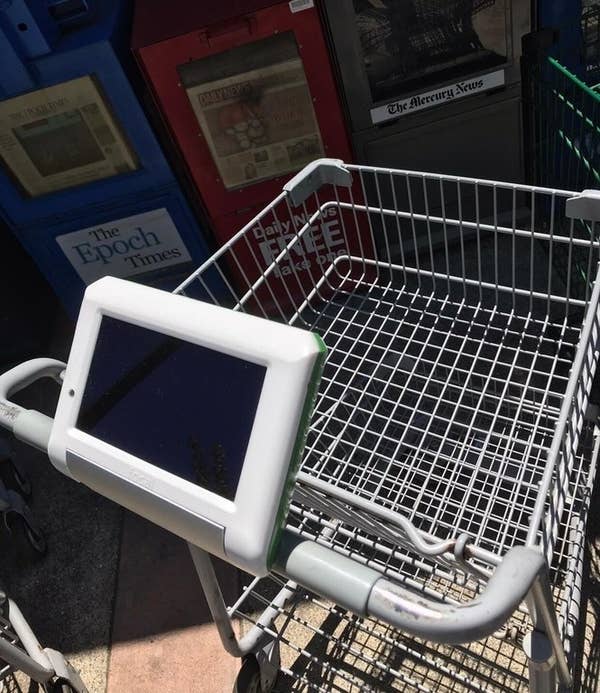 A grocery cart with a tablet on the handle