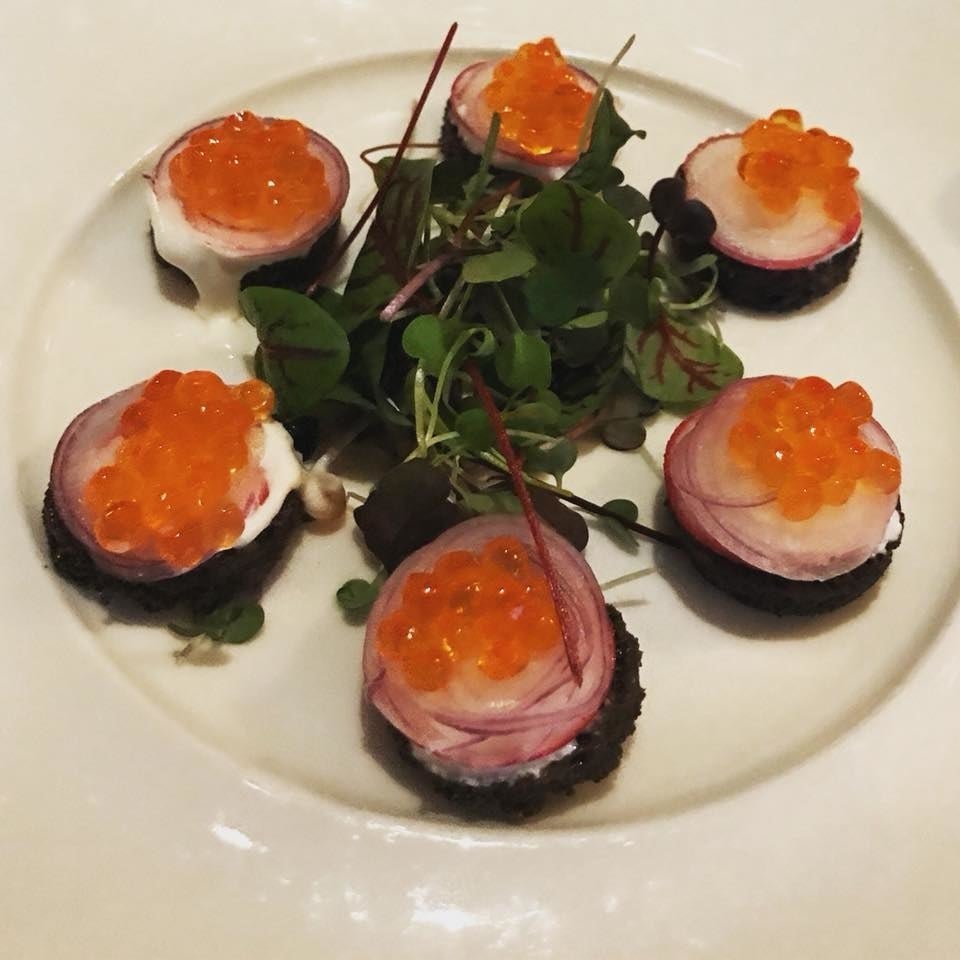The colorful ensemble of salty trout roe and crunchy shaved radish are served on top of bite-sized pumpernickel crouton infused with brown butter.