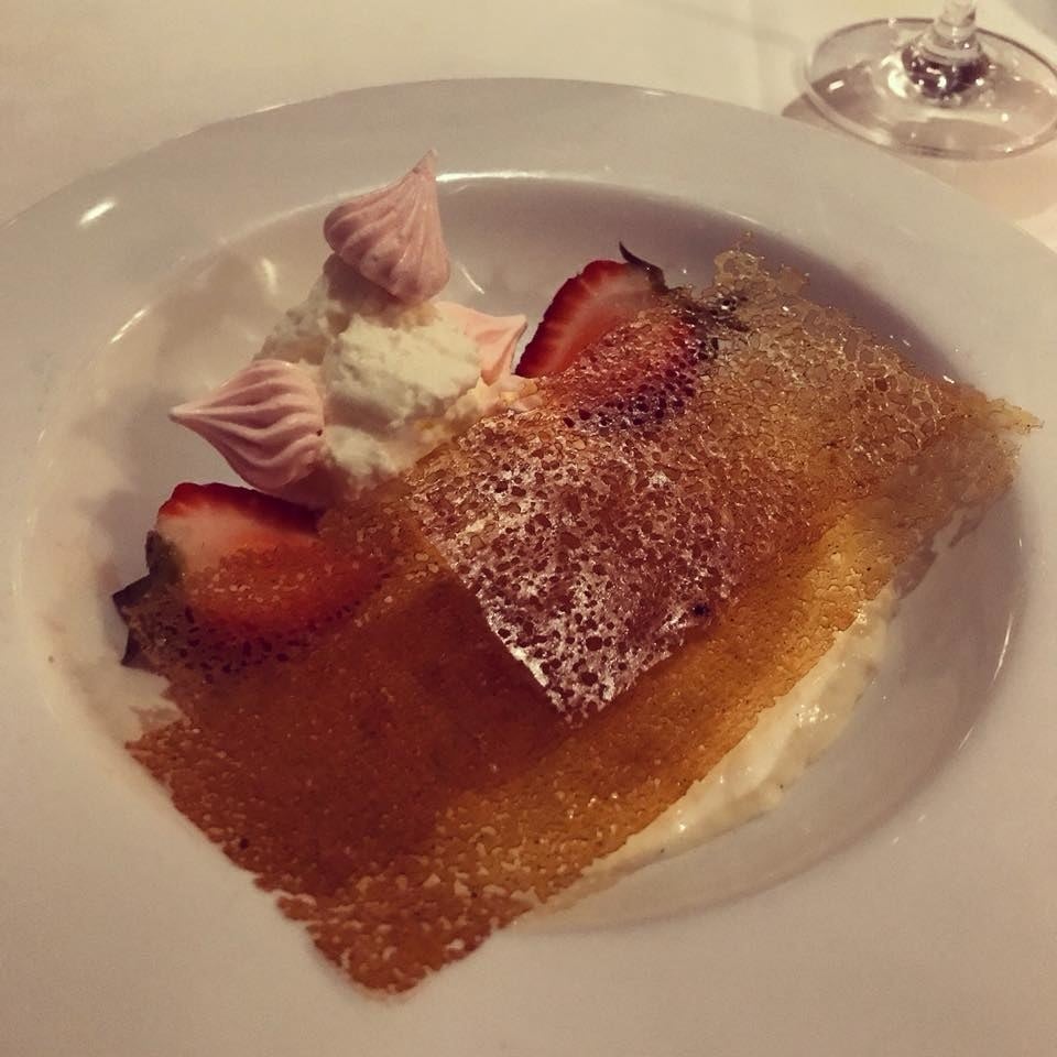 Over a bed of smooth, creamy rice pudding is a thin layer of crunchy caramelized sugar with a dollop of whipped cream, macerated strawberries, and strawberry meringue.