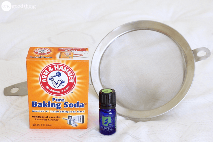 the essential oil next to a box of baking soda and a sieve