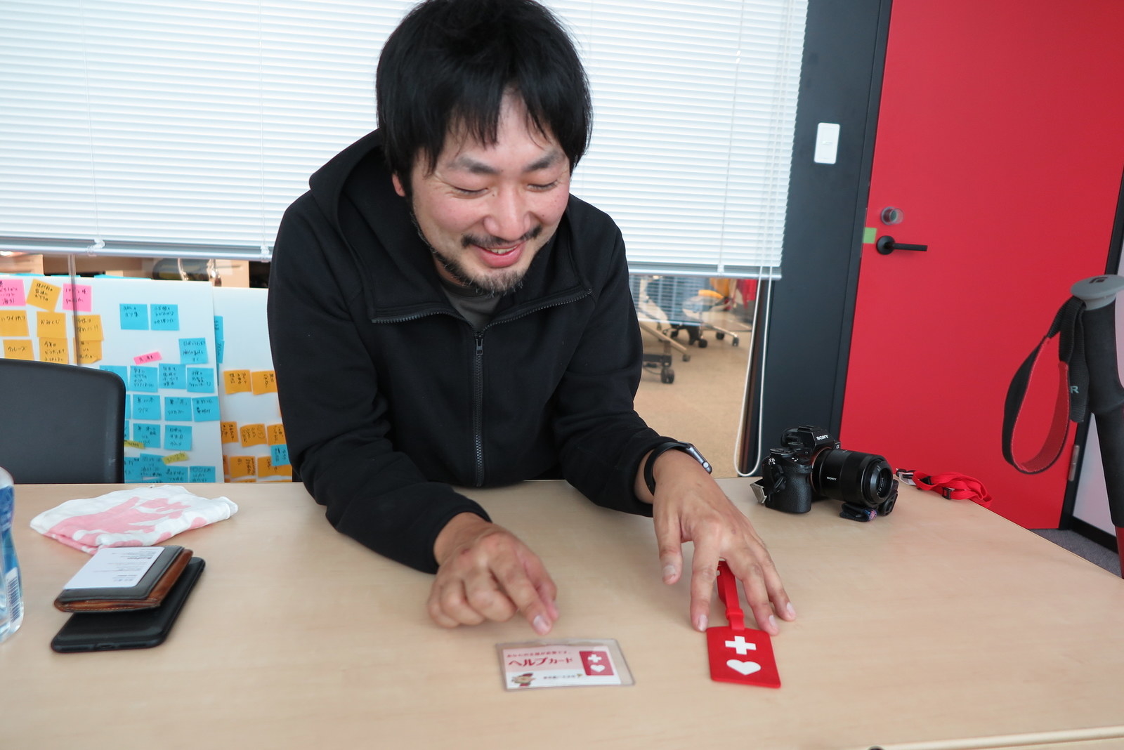 杖につけているヘルプマーク(右)とヘルプカード(左)を見せてくれる幡野さん