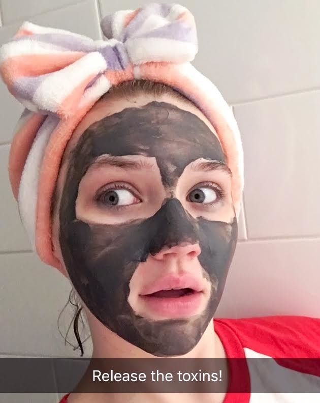 A person wearing a bow hairband and the charcoal mask