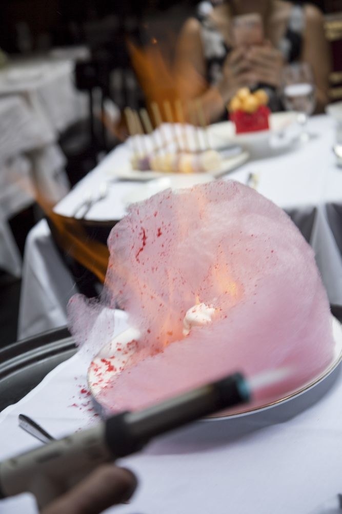 Torched on the table side, the Cotton Candy Baked Alaska is a must-order dessert - both for its taste and the presentation. The pastry chef brings out an elaborate baked Alaska covered in fluffy cotton candy, and torches with fire as it melts all over the dessert. Inside the creamy meringue are layers of strawberry and vanilla bean ice cream surrounded by vanilla cake with roasted strawberries on the side.