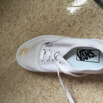 reviewer's white Vans with dirt stain