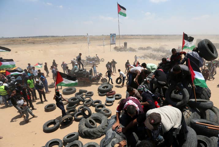 Palestinians collect tires to be burned during a protest marking the 70th anniversary of Nakba, at the Israel-Gaza border on May 15.