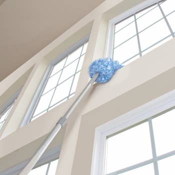360-degree duster on extension pole, wiping an extra-high windowsill