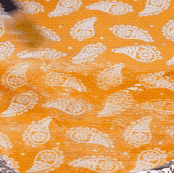 Once the cloth is completely covered, bake in a 210F (or 100C) oven for five to seven minutes. When the cloth has finished baking, brush off any excess wax and hang to dry.