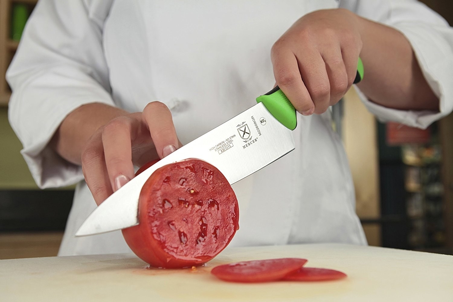 a chef slicing a tomato with the Japanese steel knife