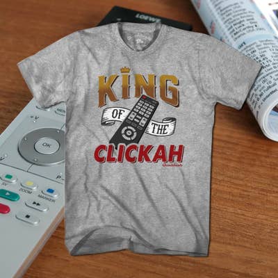 You rule over the remote. You&#x27;re in charge of the changer. You&#x27;re the King of the Clickah! If no one in the house gets to watch what they want while you&#x27;re in your throne (recliner), then grab this tee and claim your title. Perfect for dad, or any television tyrant in your life.