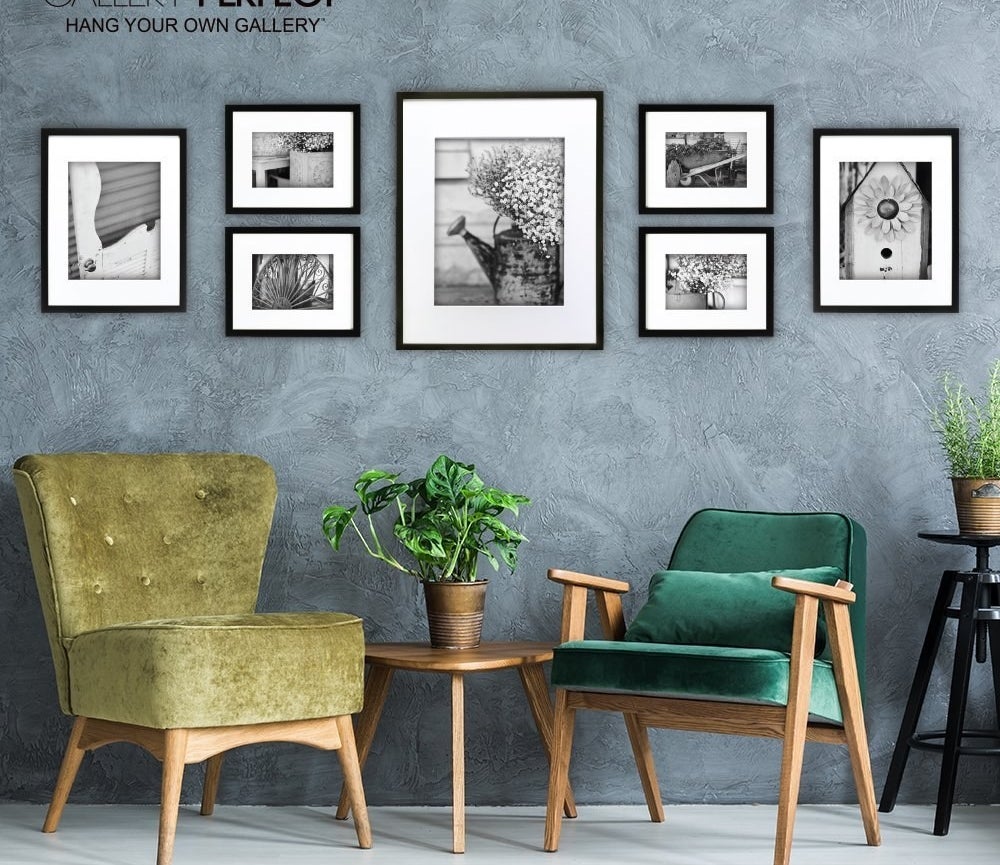 A set of seven differently sized photo frames arranged on a wall