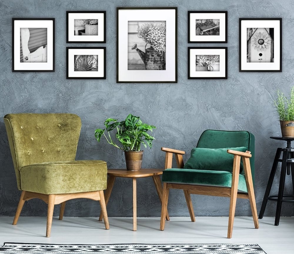 A set of seven differently sized photo frames arranged on a wall