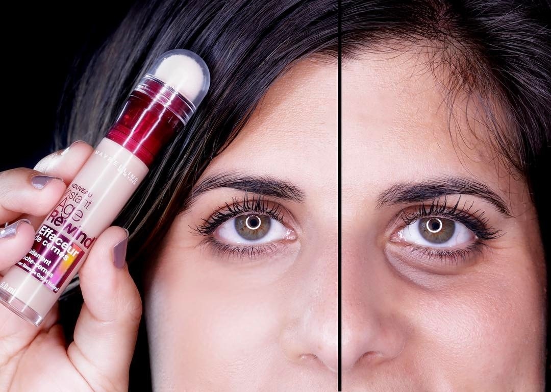 A reviewer holding the concealer to show the sponge applicator, and a before and after of one eye without the concealer on, with a pronounced dark circle, and another eye with concealer, with barely any dark circle
