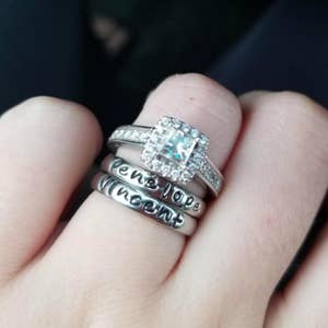 same set of silver stackable rings below wedding band on reviewer's ring finger