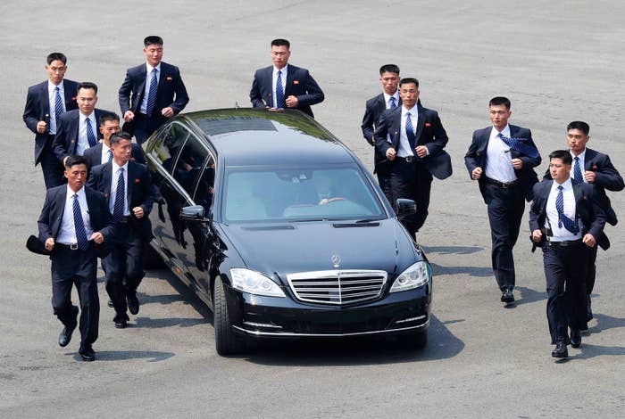 North Korean security personnel run alongside the car carrying North Korean leader Kim Jong Un after a morning session of the summit with South Korean President Moon Jae-in on April 27.