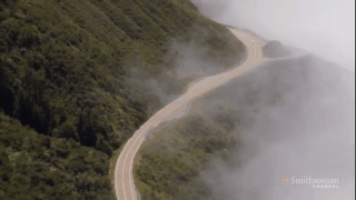 gif of aerial view of foggy mountain road
