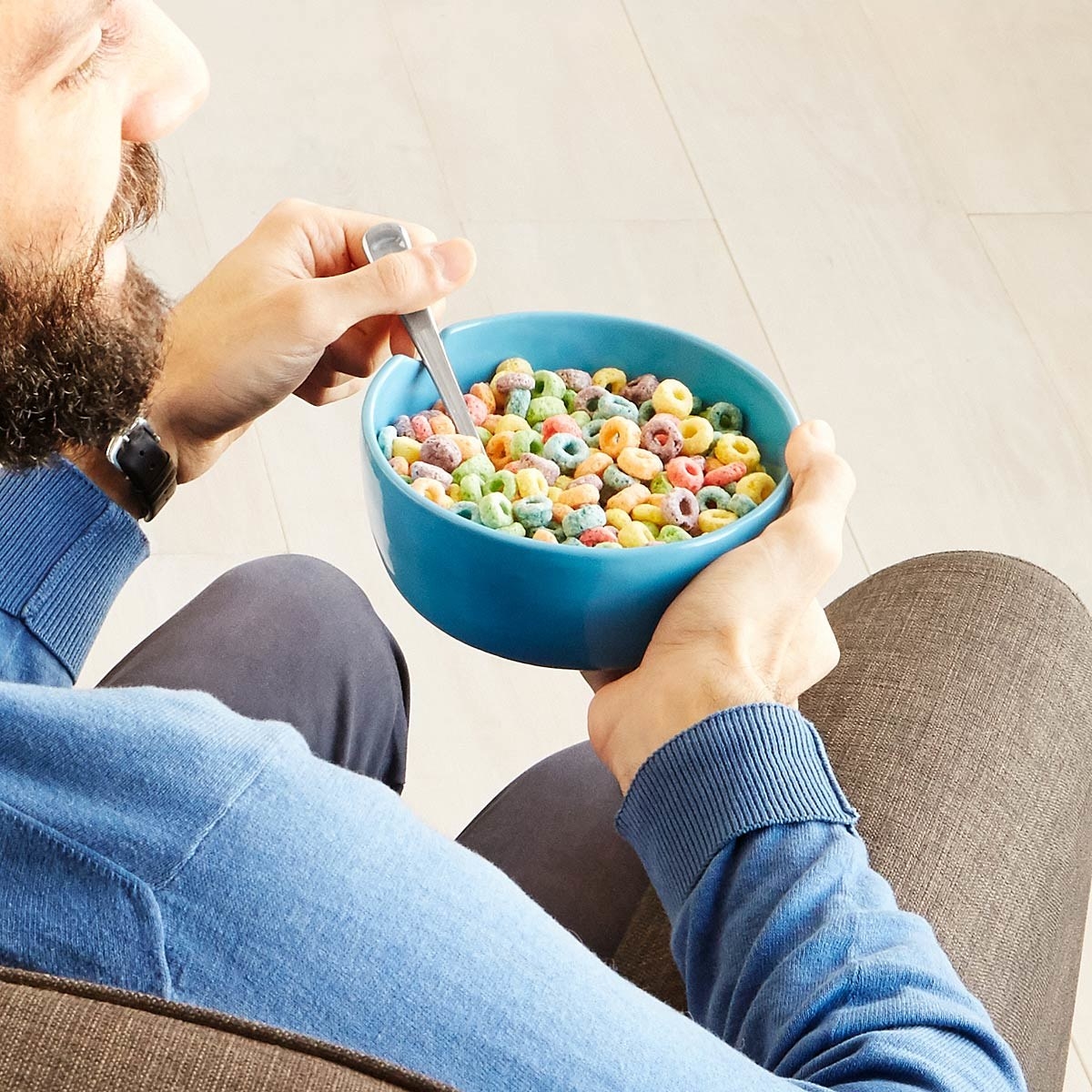 man easily holding a bowl on the couch