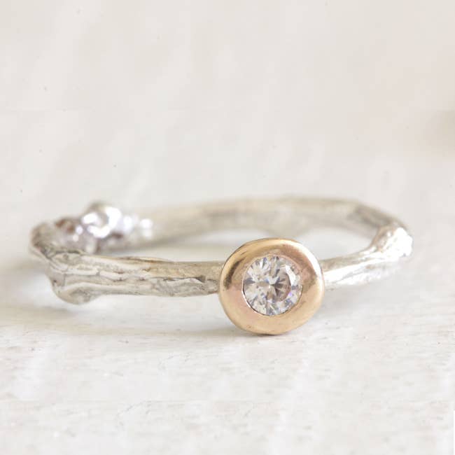 the ring that has a vintage look on the band and a center diamond inside of a gold halo
