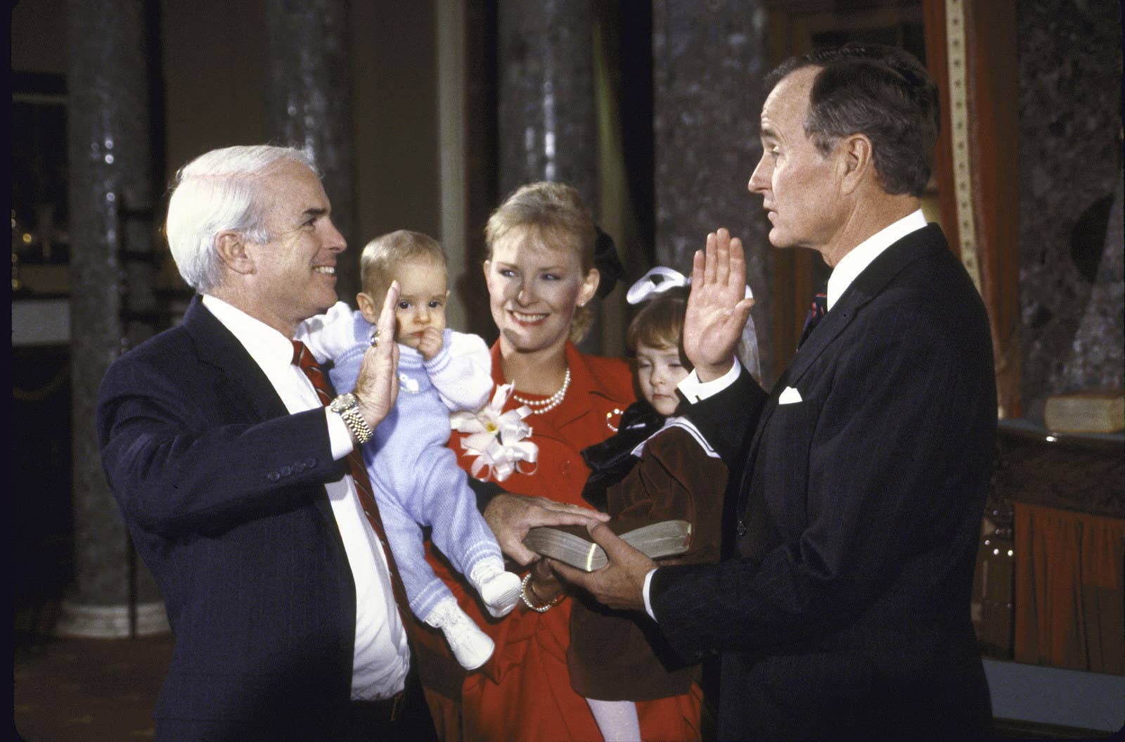 Vice President George H.W. Bush (right) swears in John McCain as US senatorfrom Arizona in 1987, with his family watching on.
