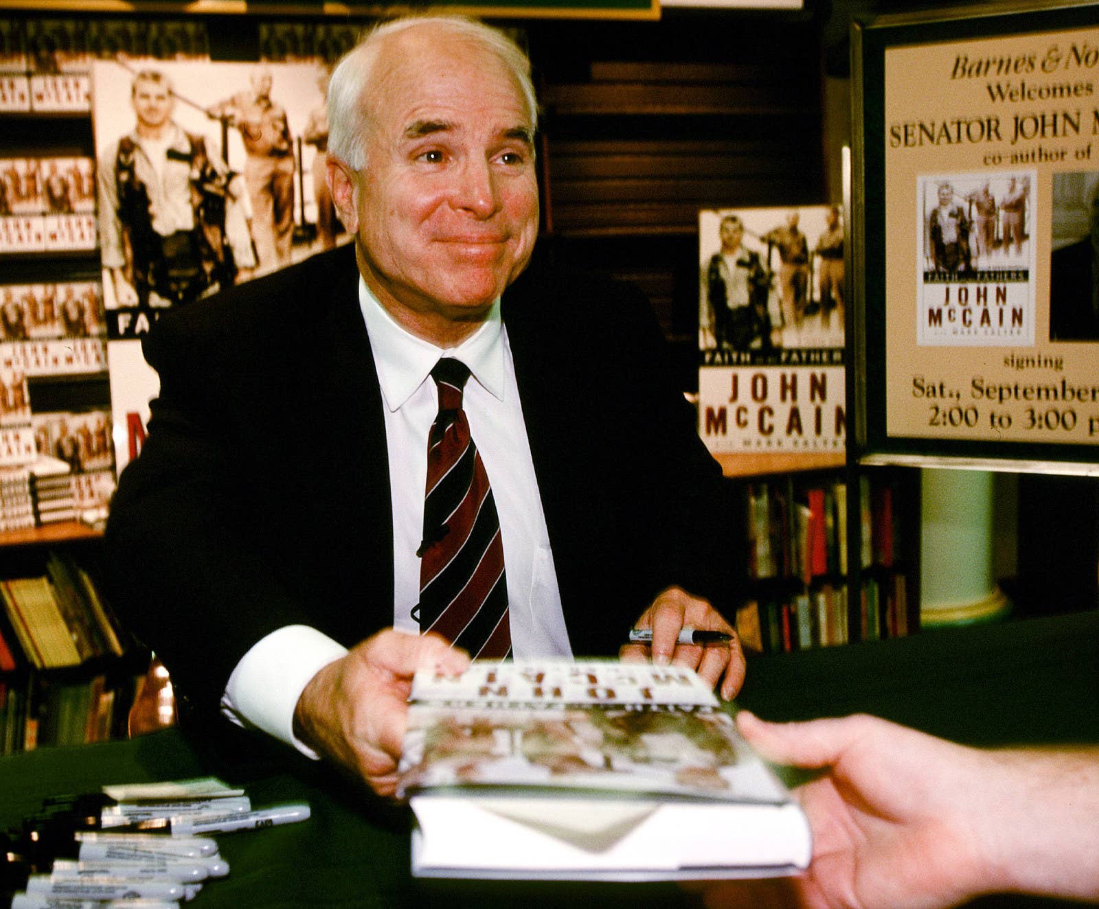 McCain, then a Republican presidential candidate, talks with a supporter at a book signing for his book Faith of My Father in Manchester, New Hampshire, on Sept. 11, 1999.