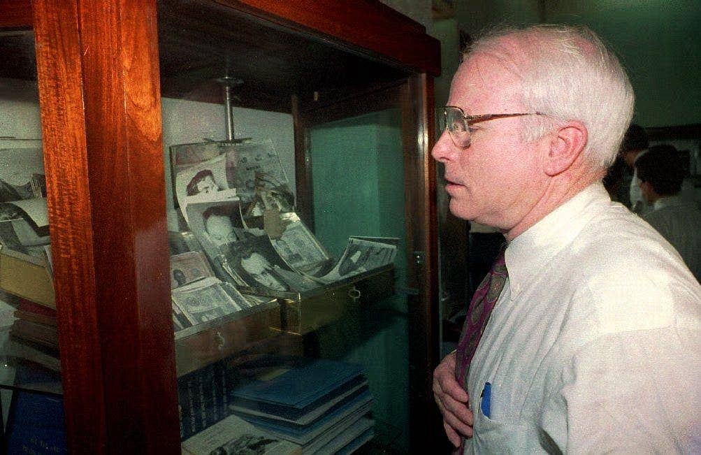 McCain looks at a display of personal belongings of American POWs at the joint POW/MIA archives center in the Vietnam Military History Museum on May 31, 1993.