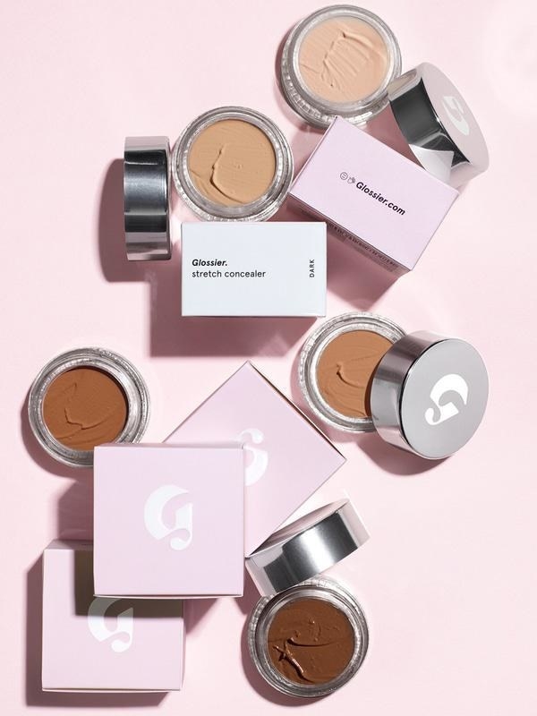 different shades of the concealer styled on pink background