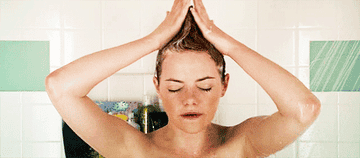 A person taking a shower and washing their hair