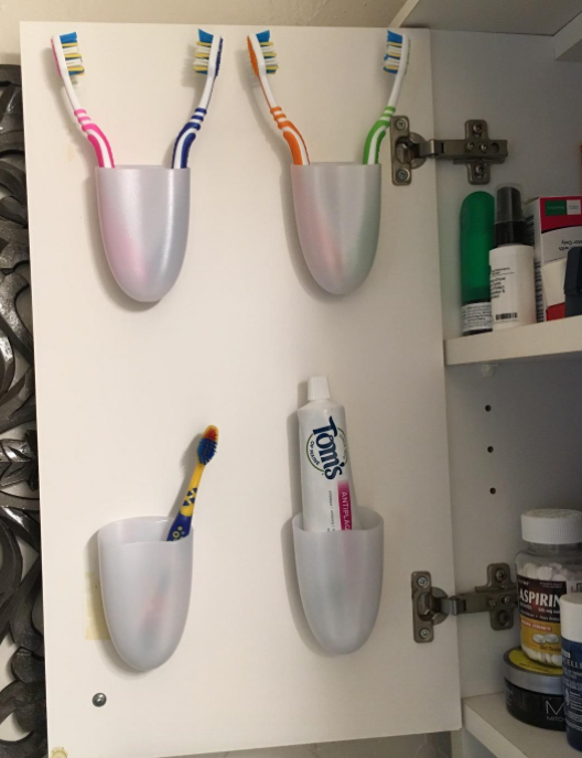 Toothbrushes in holders attached to cabinet door 