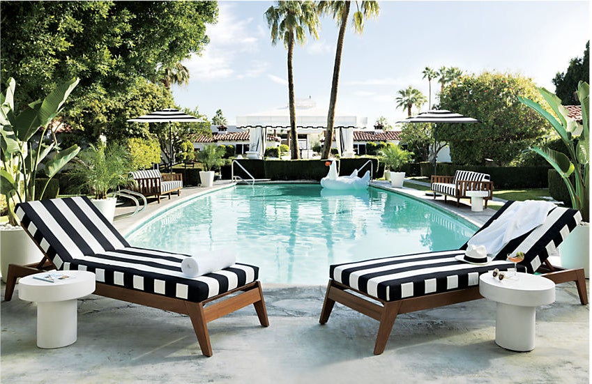 two black and white striped loungers next to a pool