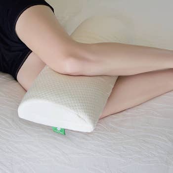 model sleeping with pillow in between their legs