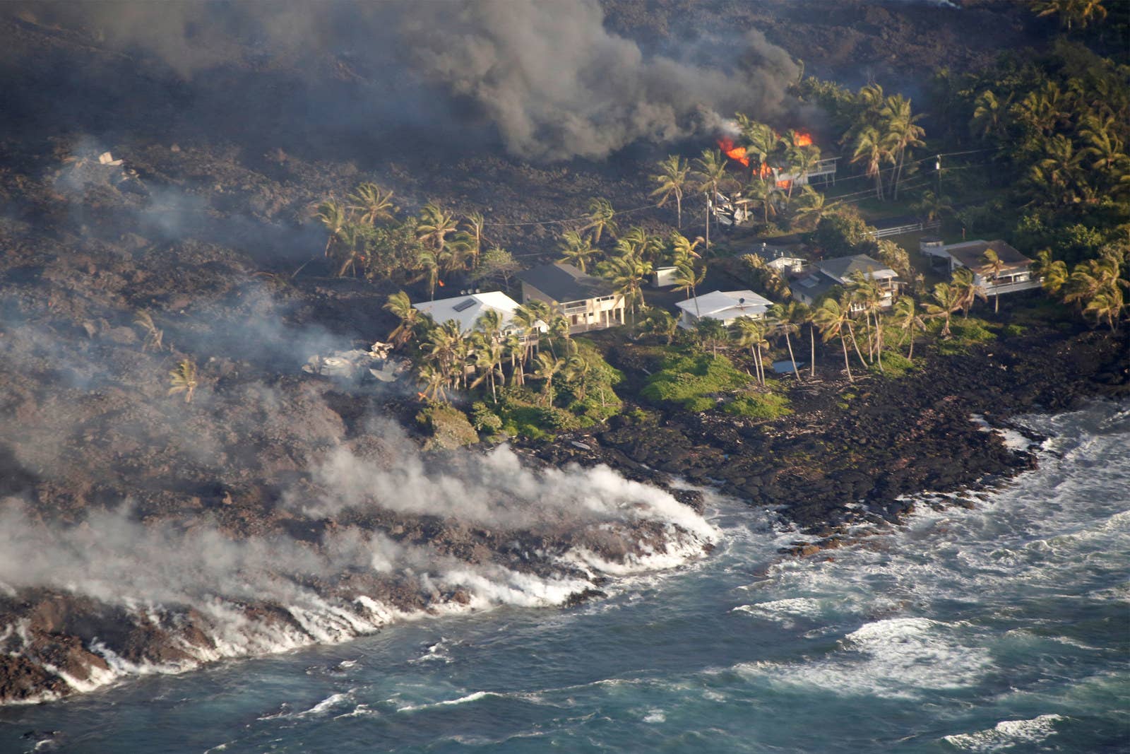 Homes burn from lava that also flowed into the ocean near Kapoho.